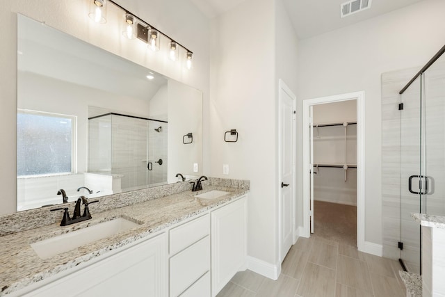 bathroom featuring walk in shower and vanity