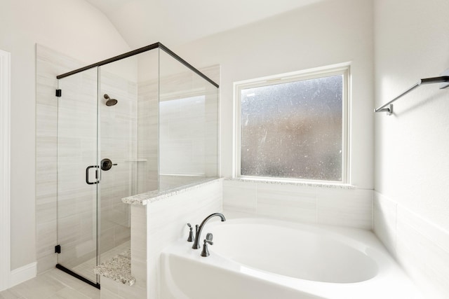 bathroom with a healthy amount of sunlight, lofted ceiling, and independent shower and bath