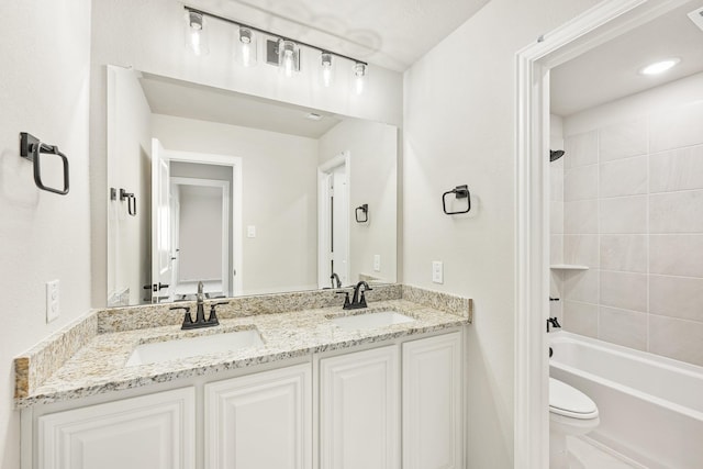 full bathroom with toilet, vanity, and tiled shower / bath