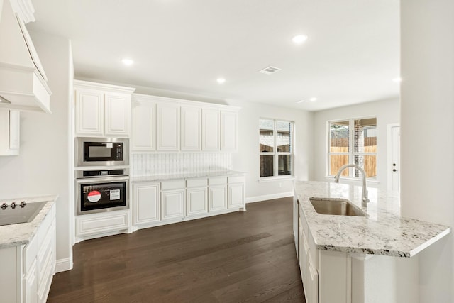 kitchen with white cabinets, sink, stainless steel oven, custom range hood, and built in microwave