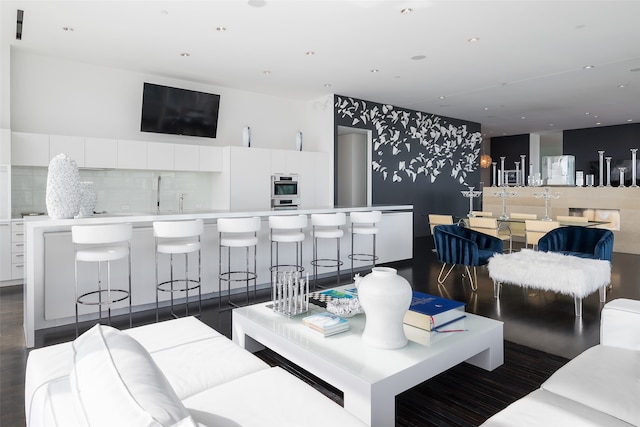 kitchen featuring a kitchen breakfast bar, white cabinets, stainless steel double oven, and plenty of natural light