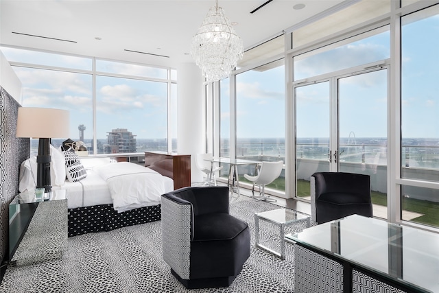 bedroom featuring a notable chandelier, floor to ceiling windows, and a water view