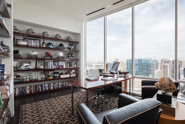 home office with floor to ceiling windows and hardwood / wood-style flooring