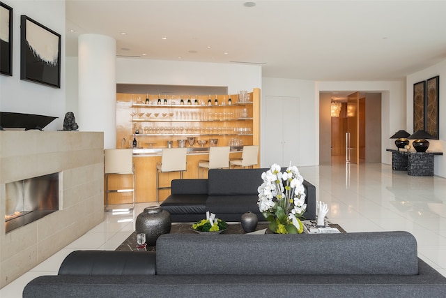 tiled living room featuring a tiled fireplace and bar area