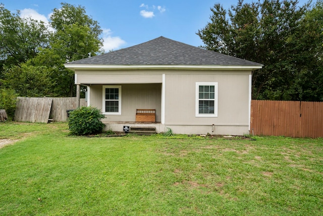 back of house with a lawn and covered porch