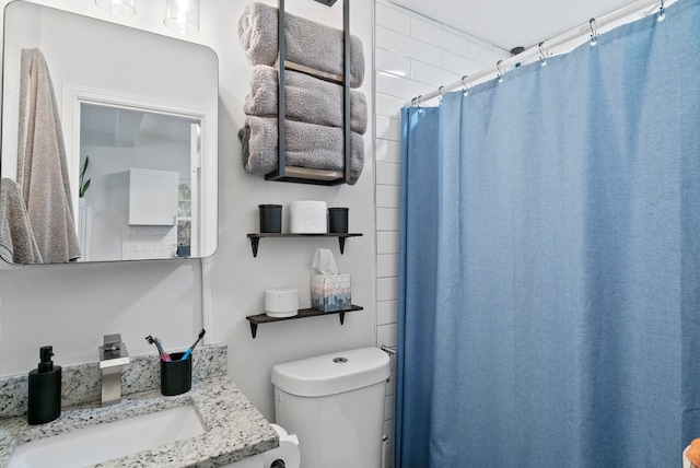 bathroom featuring a shower with curtain, toilet, and vanity