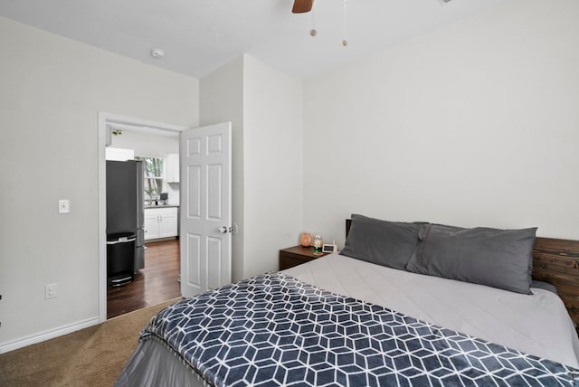 carpeted bedroom featuring stainless steel fridge and ceiling fan