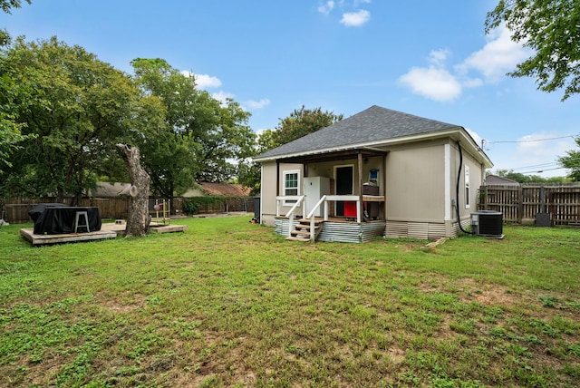 exterior space with central AC and a lawn