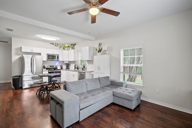 living room featuring dark wood-type flooring, sink, and ceiling fan