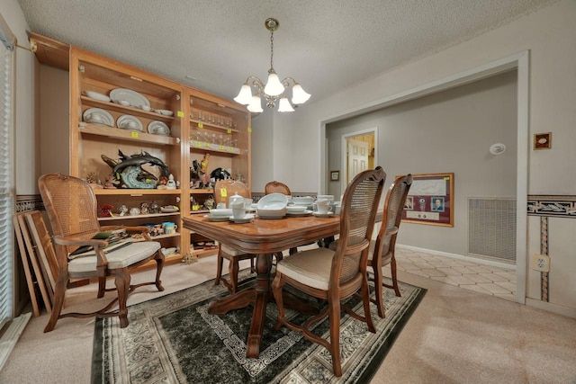 carpeted dining space featuring an inviting chandelier and a textured ceiling