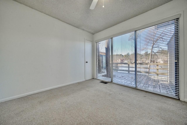 unfurnished room with ceiling fan, carpet, lofted ceiling, and a textured ceiling