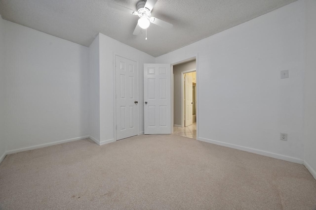 carpeted empty room with ceiling fan and a textured ceiling