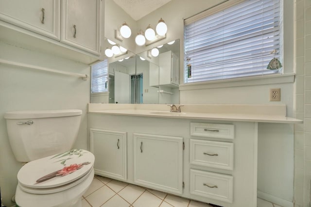 bathroom with tile patterned flooring, vanity, and toilet