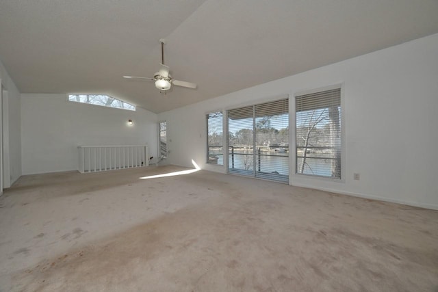 carpeted empty room featuring lofted ceiling, a healthy amount of sunlight, and ceiling fan