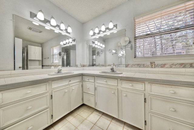 bathroom with vanity, tile patterned floors, and a textured ceiling