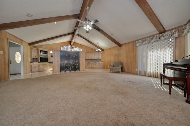 living room with ceiling fan, wood walls, light carpet, and vaulted ceiling with beams