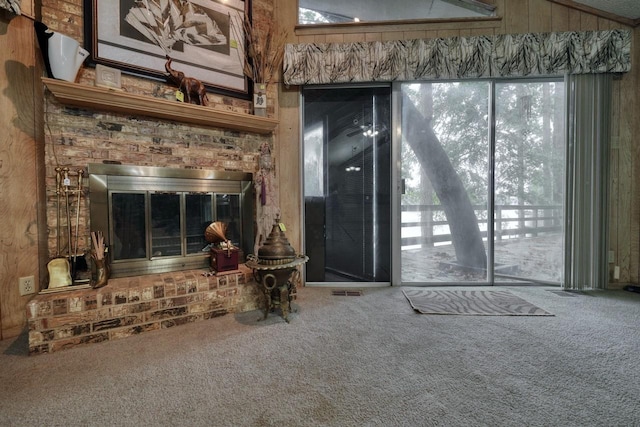 living room featuring a brick fireplace, carpet floors, and wood walls