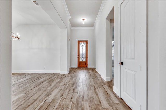 entrance foyer with crown molding, light hardwood / wood-style flooring, and a chandelier