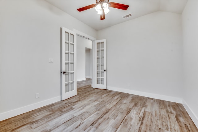 empty room featuring french doors, light wood-type flooring, ceiling fan, and lofted ceiling