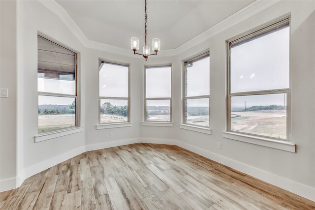 unfurnished dining area with crown molding, light hardwood / wood-style floors, and an inviting chandelier