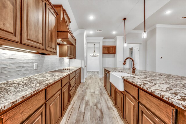 kitchen featuring black electric stovetop, light wood-type flooring, ornamental molding, and sink