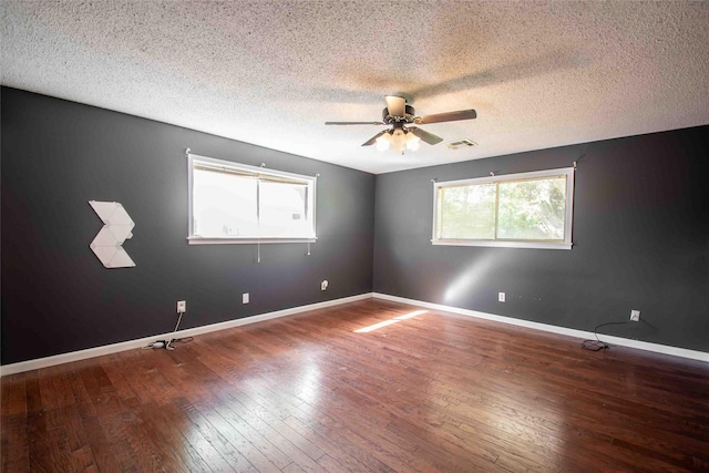 spare room with a textured ceiling, ceiling fan, and dark hardwood / wood-style flooring