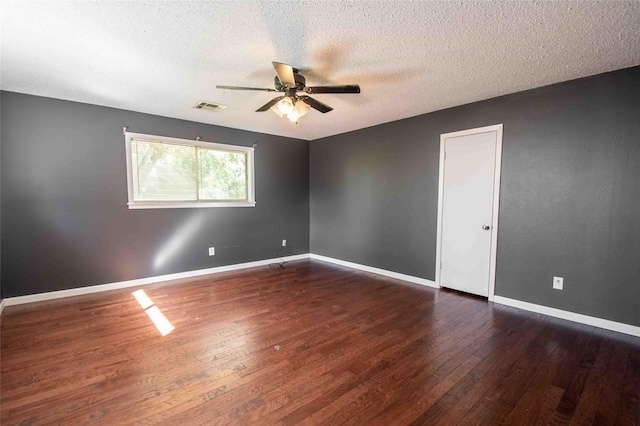 unfurnished bedroom with ceiling fan, dark wood-type flooring, a textured ceiling, and ensuite bath