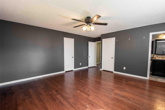 spare room with brick wall, dark wood-type flooring, and a textured ceiling