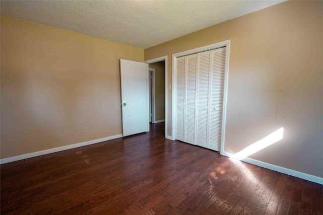 spare room featuring a wealth of natural light, dark hardwood / wood-style flooring, and a textured ceiling