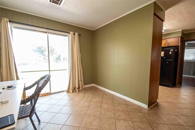 tiled home office featuring ornamental molding and a textured ceiling