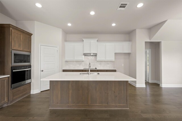 spare room featuring visible vents, a healthy amount of sunlight, baseboards, and dark wood-style flooring