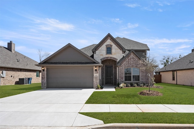 french provincial home featuring a front yard, roof with shingles, concrete driveway, a garage, and brick siding