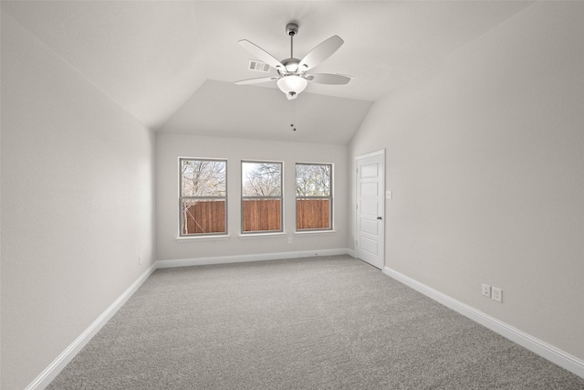 unfurnished room featuring a ceiling fan, carpet, visible vents, baseboards, and lofted ceiling