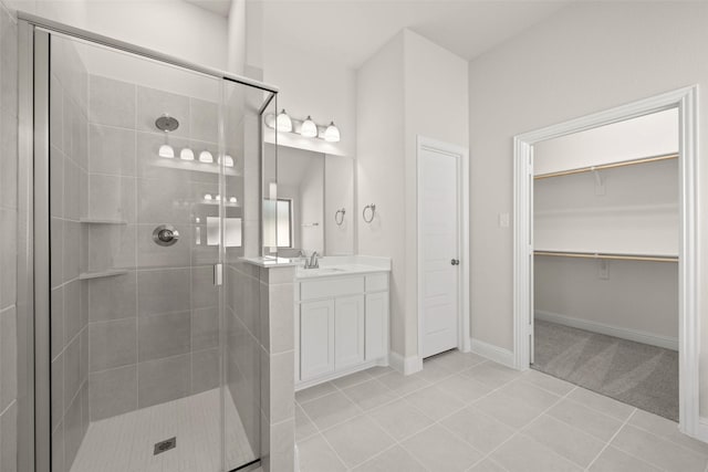 bathroom featuring vanity, tile patterned floors, a walk in closet, and a stall shower