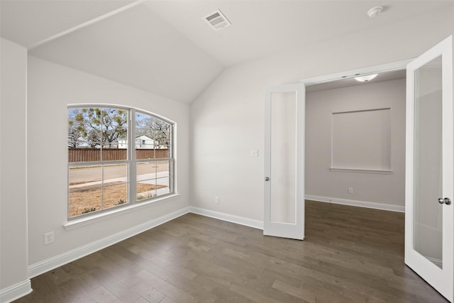 unfurnished room featuring visible vents, french doors, baseboards, dark wood-style flooring, and vaulted ceiling