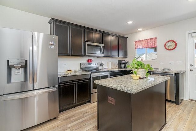 kitchen featuring dark brown cabinets, a kitchen island, stainless steel appliances, and light wood-type flooring