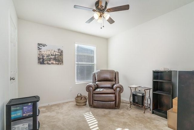 living area with light carpet and ceiling fan