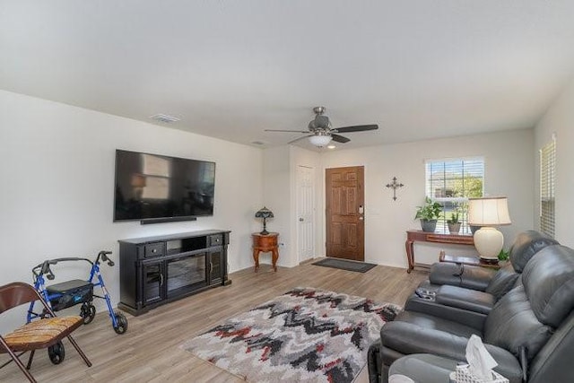 living room featuring light hardwood / wood-style flooring and ceiling fan