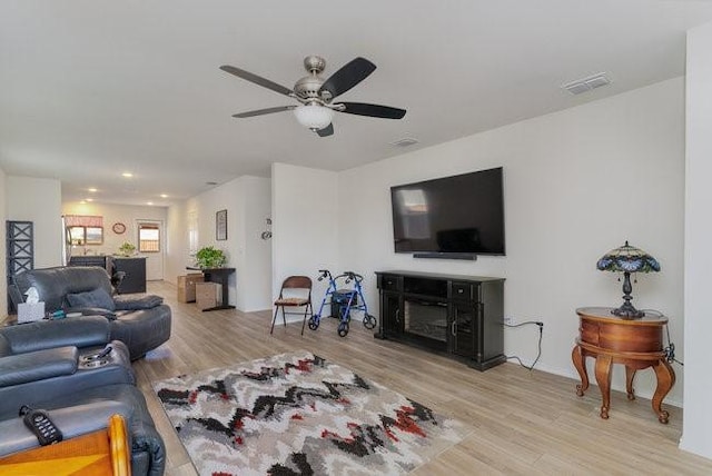 living room featuring light wood-type flooring and ceiling fan