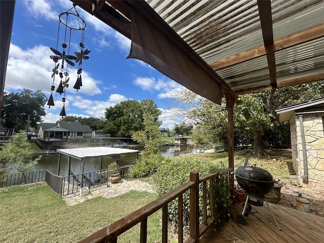 wooden terrace with a yard and a water view