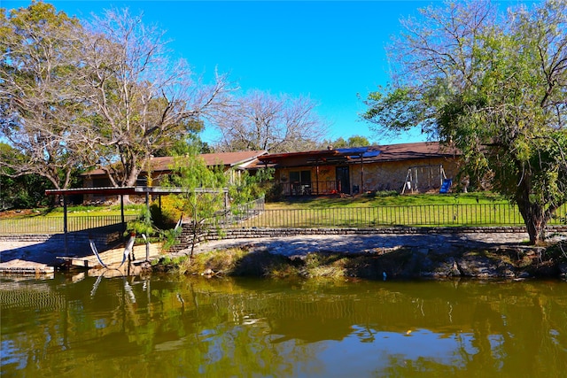 back of property featuring a yard and a water view