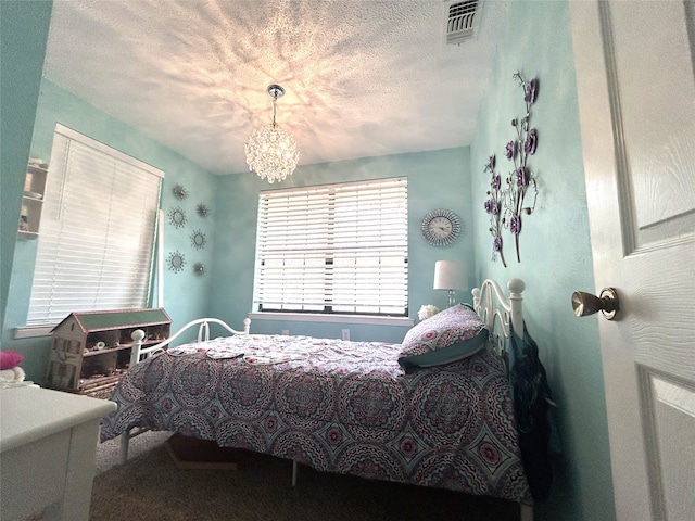 bedroom featuring a textured ceiling and an inviting chandelier