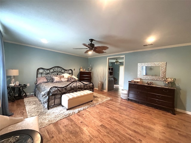 bedroom with hardwood / wood-style flooring, ceiling fan, and crown molding