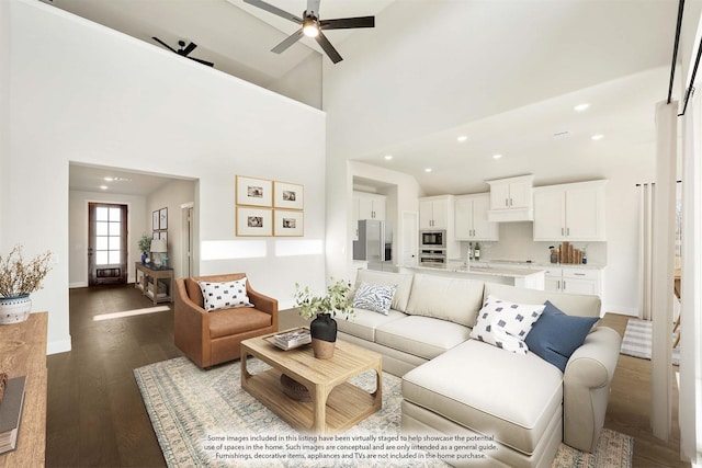 living room with dark hardwood / wood-style floors, high vaulted ceiling, and ceiling fan