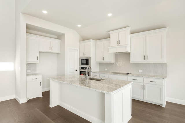 kitchen with black appliances, white cabinetry, sink, a kitchen island with sink, and light stone counters