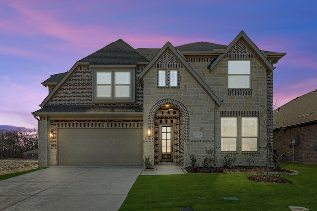 view of front of property with a yard and a garage