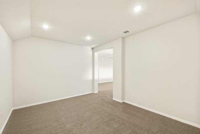 spare room featuring carpet floors and lofted ceiling