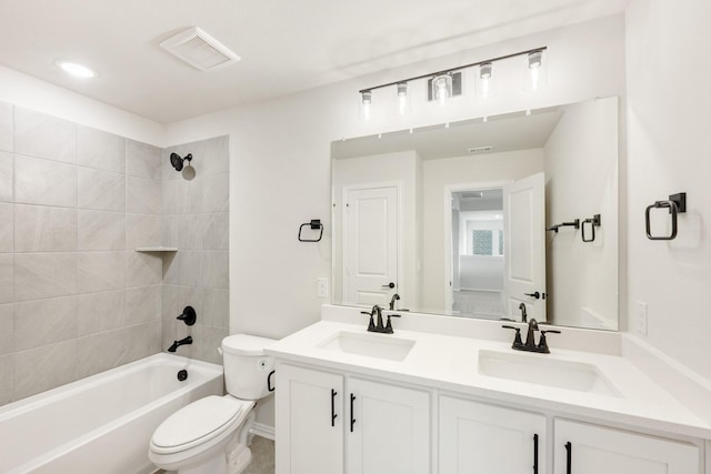 full bathroom with toilet, tiled shower / bath, and vanity