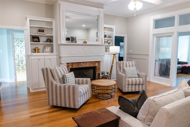 living room with crown molding, light hardwood / wood-style flooring, and ceiling fan