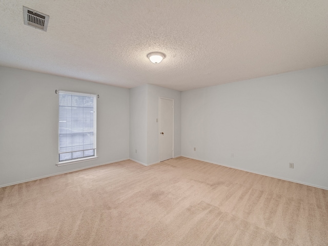 carpeted empty room with a textured ceiling